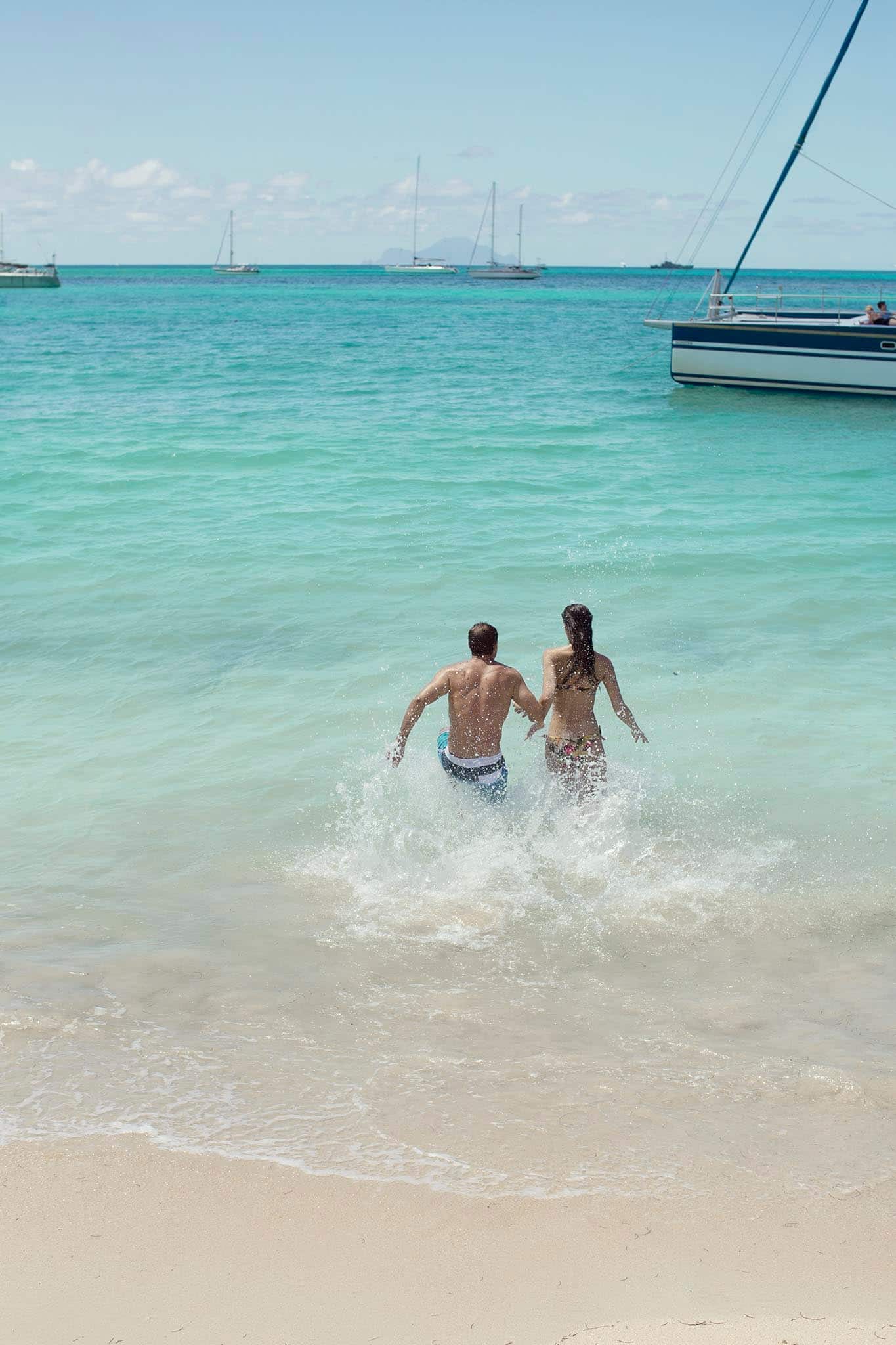 Couple running into water.