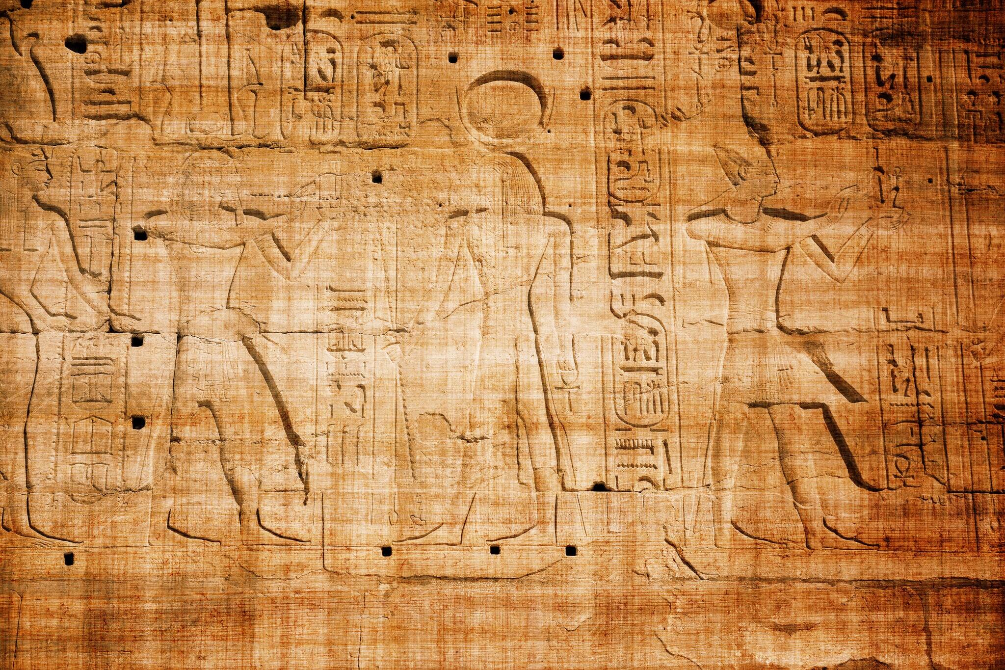 old egypt hieroglyphs carved on the stone with papyrus scratches
