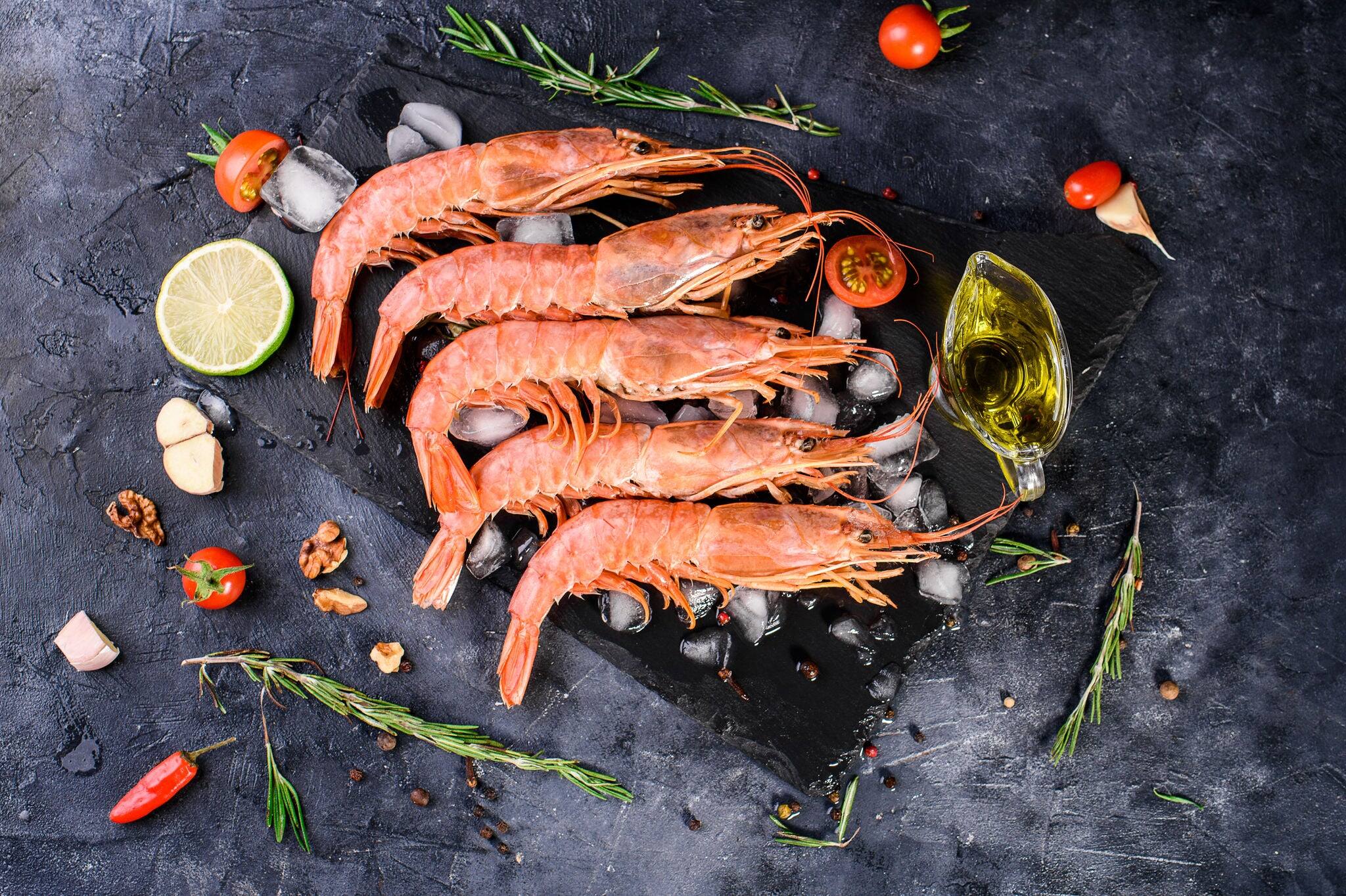 Five large iced langoustines, vegetables, spices, sprigs of defatin, olive oil, lime. Omega, seafood healthy and delicious food