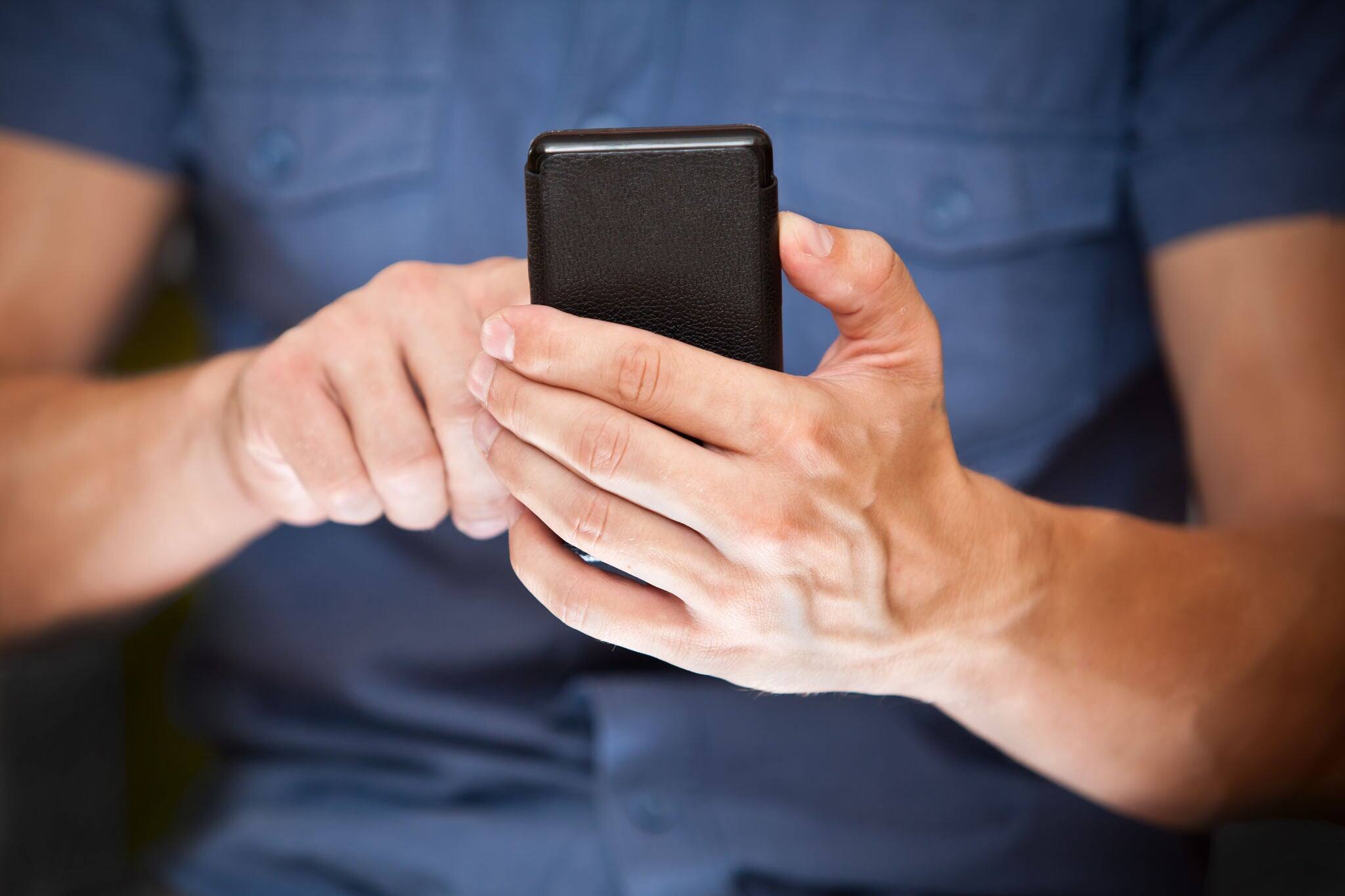 Close up of a man using mobile smart phone