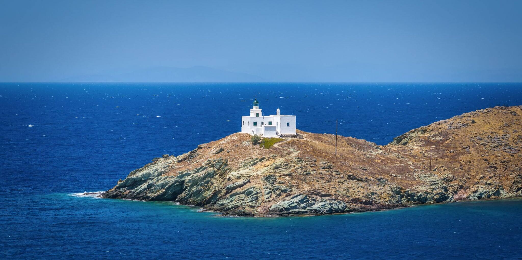 Aerial view of the lighthouse and Agios Nikolaos Church entering the port of Tzia, Kea island, Cyclades, Greece