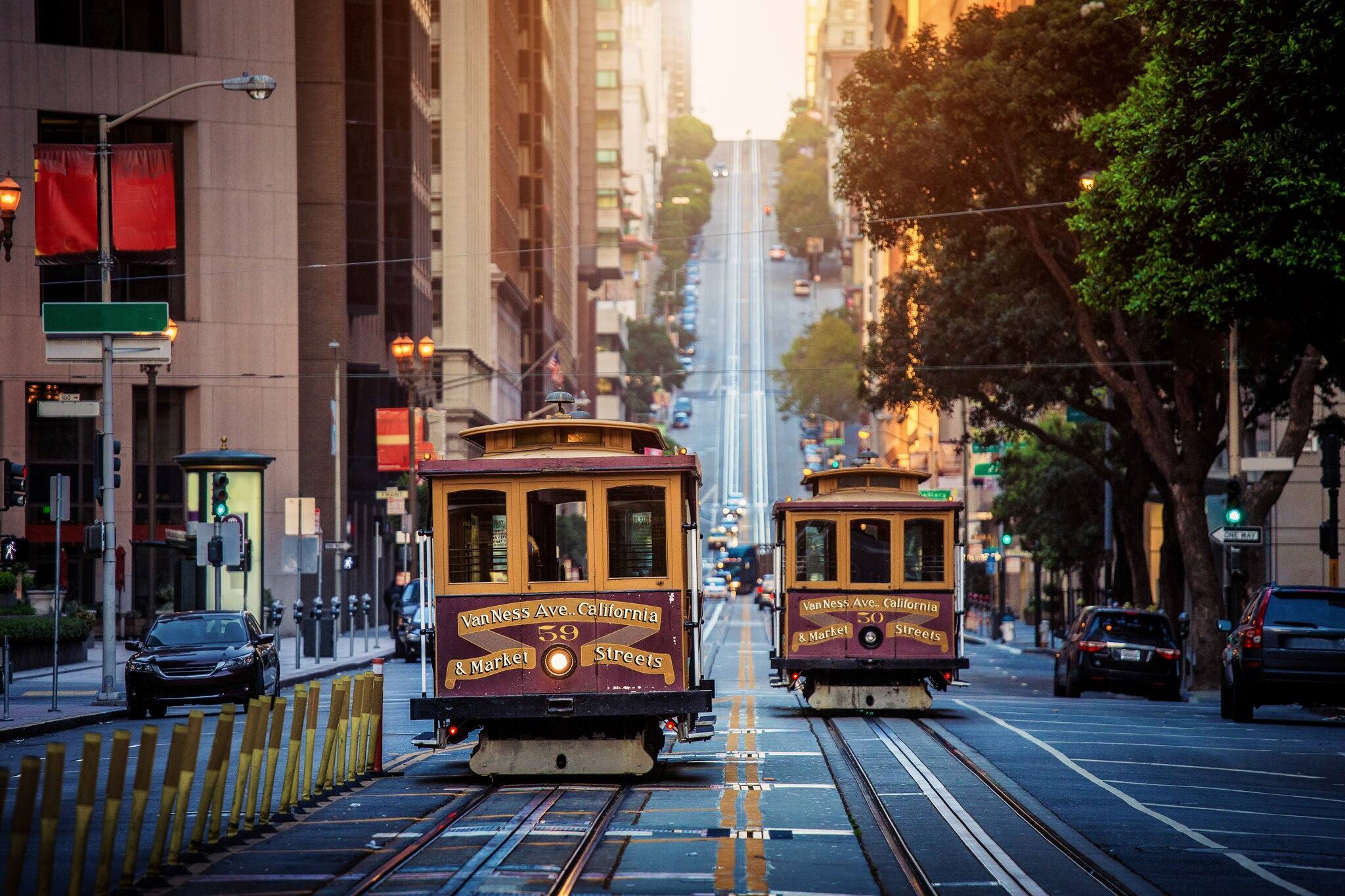 Classic view of historic traditional Cable Cars riding on famous California Street in morning light at sunrise with retro vintage style cross processing filter effect, San Francisco, California, USA
