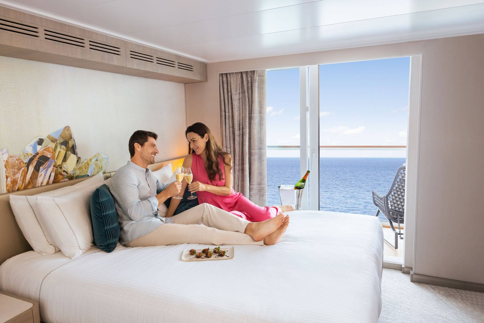 A couple relaxing in a Prima balcony stateroom