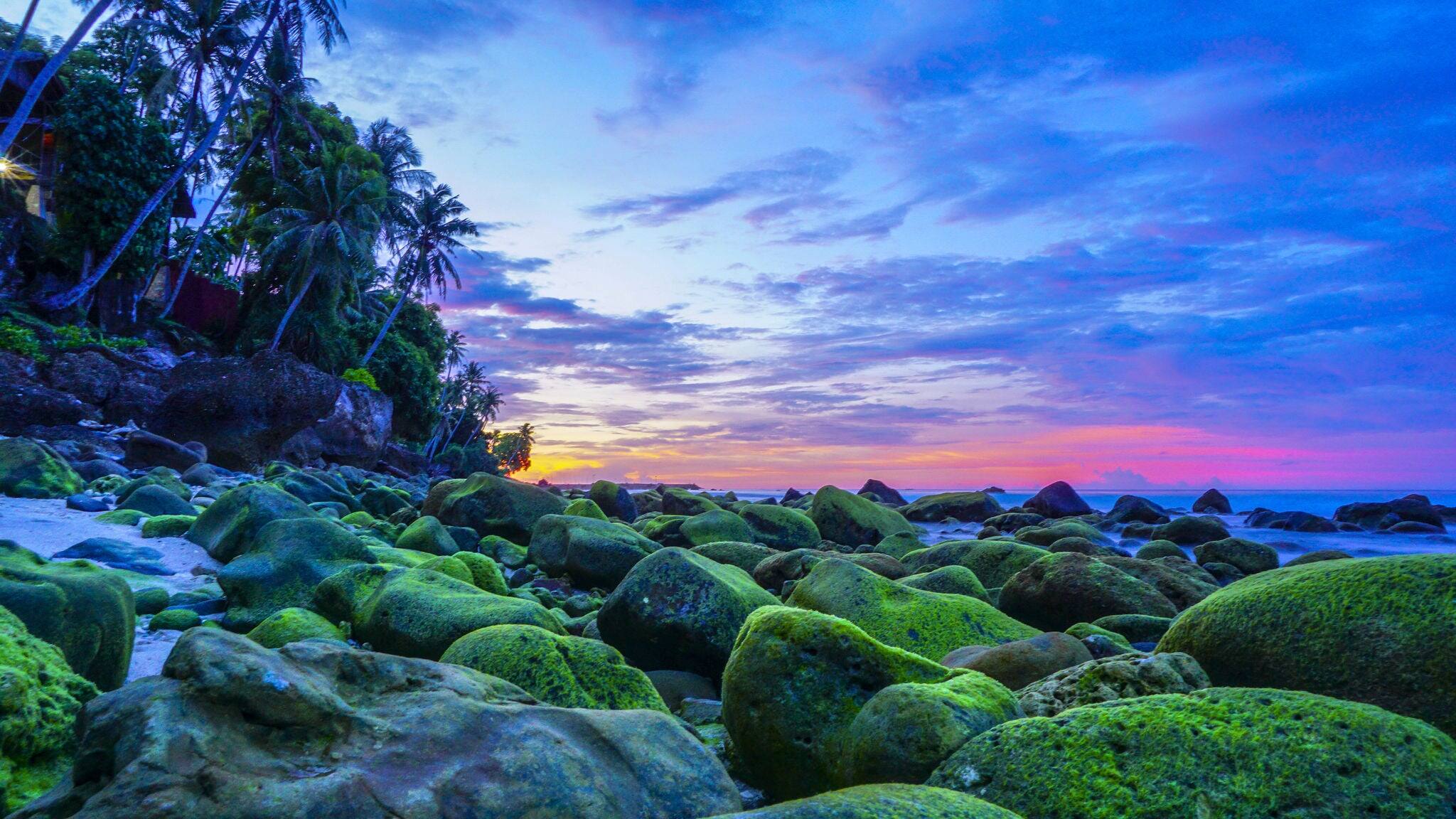 Sunset at Pulau Weh Sabang Acheh Indonesia from low angle with green moss formation on the rocks
