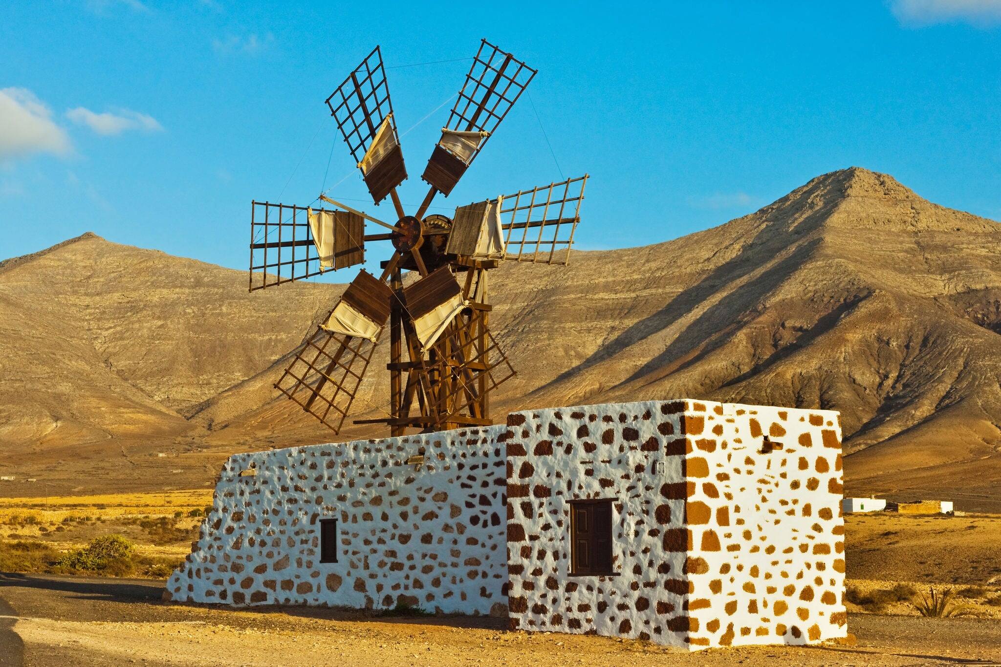 Windmill in the central valley and the 625m high churillos mountain beyond, tefia, puerto del rosario, fuerteventura, canary islands, spain, europe