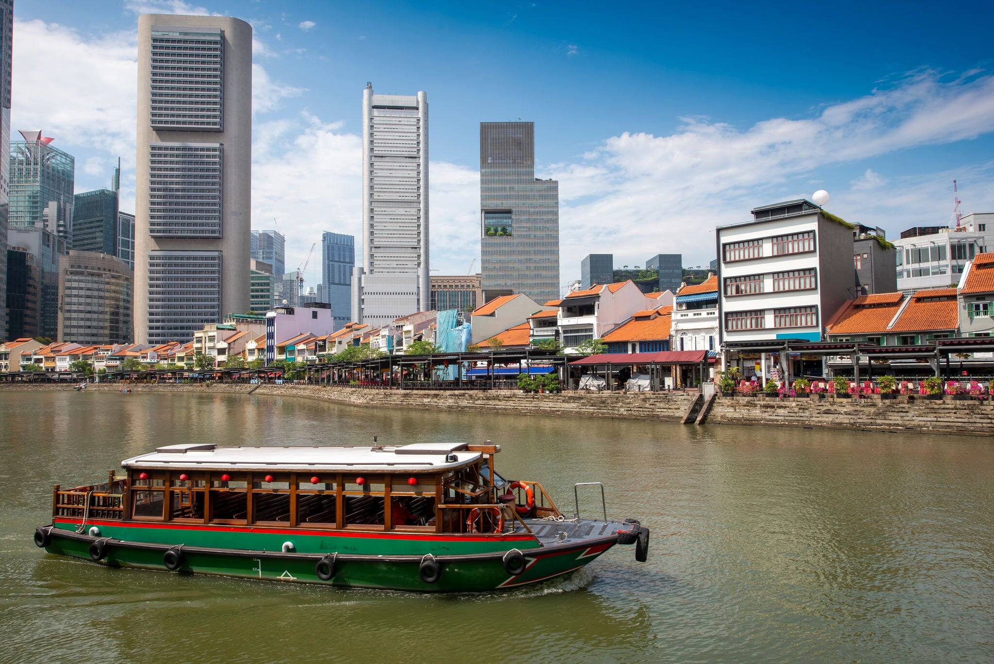 Wooden boat floating on the river at Clarke Quay area along Singapore River.