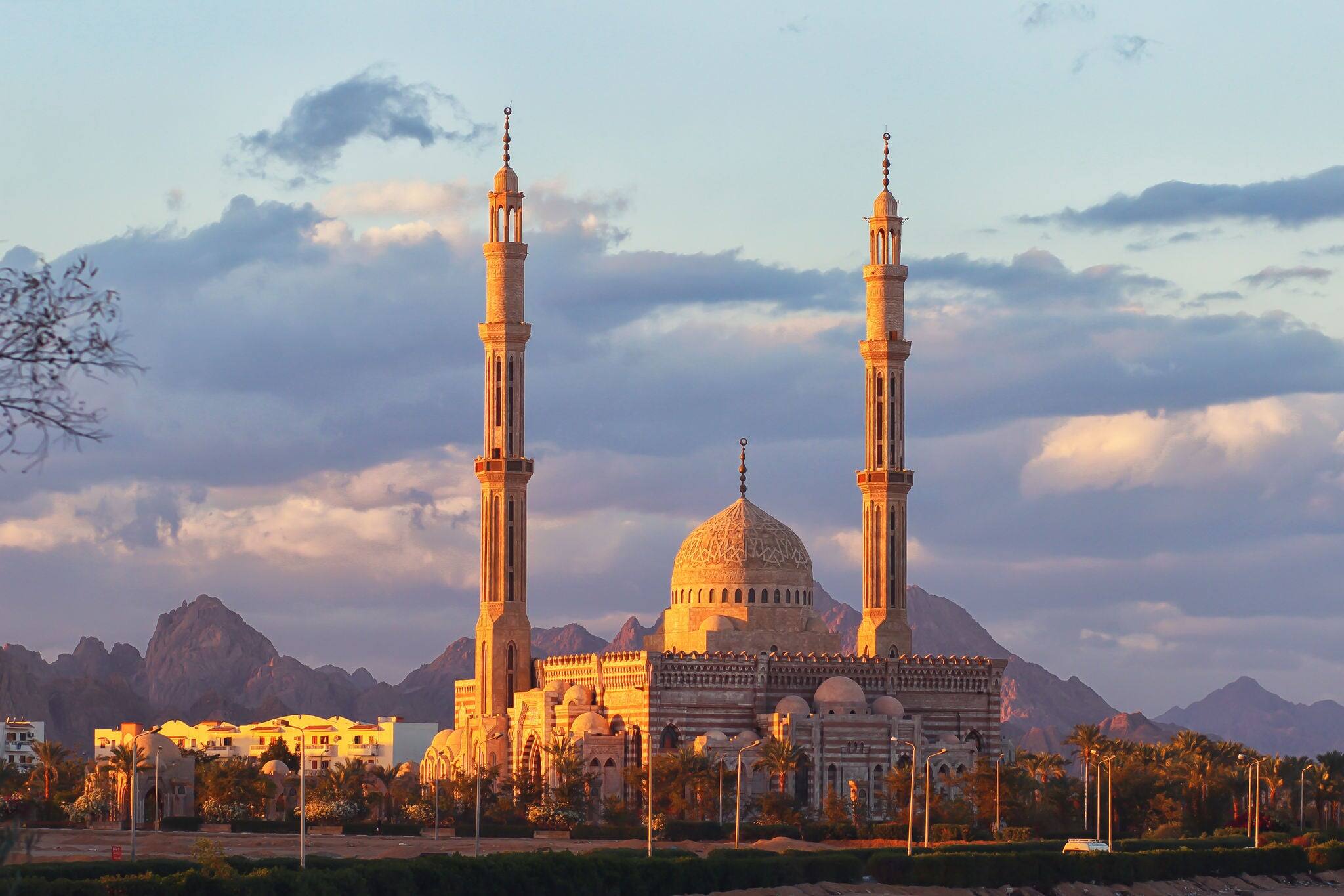 One of the main mosques in touristic city of Sharm el Sheikh, Egypt, at sunset. Cloudy sky & mountains background.