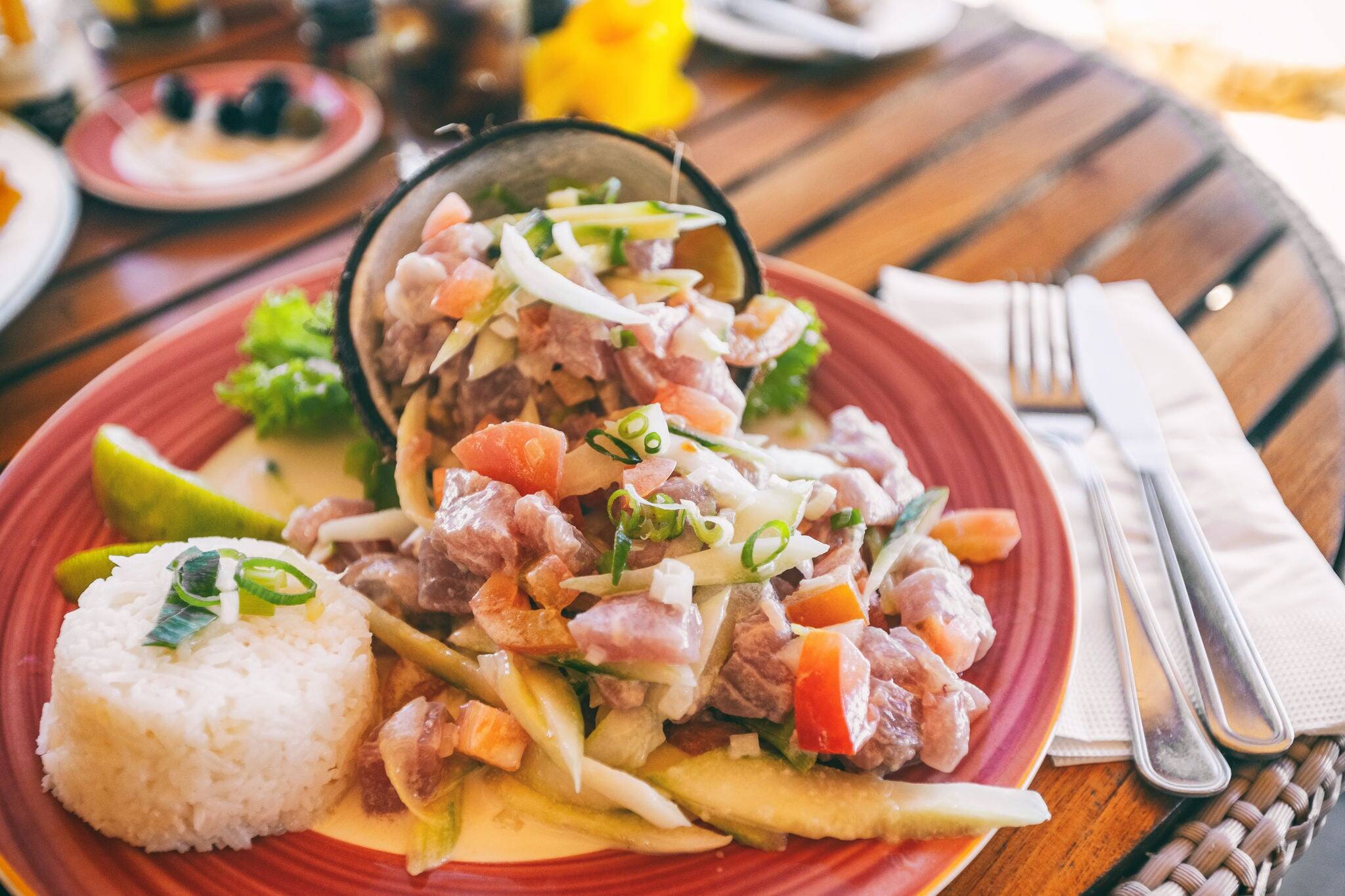 Tahiti food National dish local typical cuisine - Tahitian Raw Fish salad called Poisson Cru in French Polynesia. Top view of hotel restaurant meal in Bora Bora.