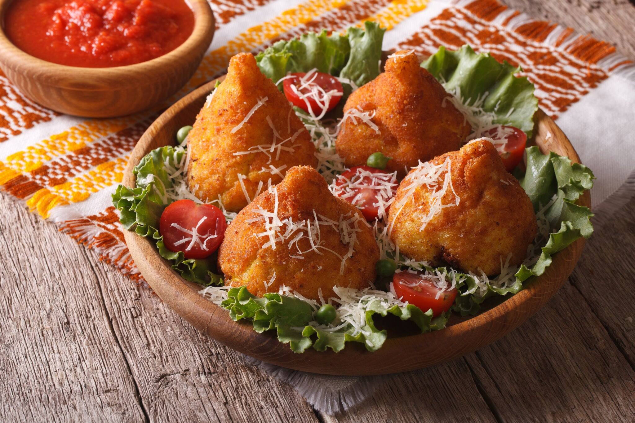 Arancini rice balls stuffed with meat and tomato sauce closeup on a table. horizontal