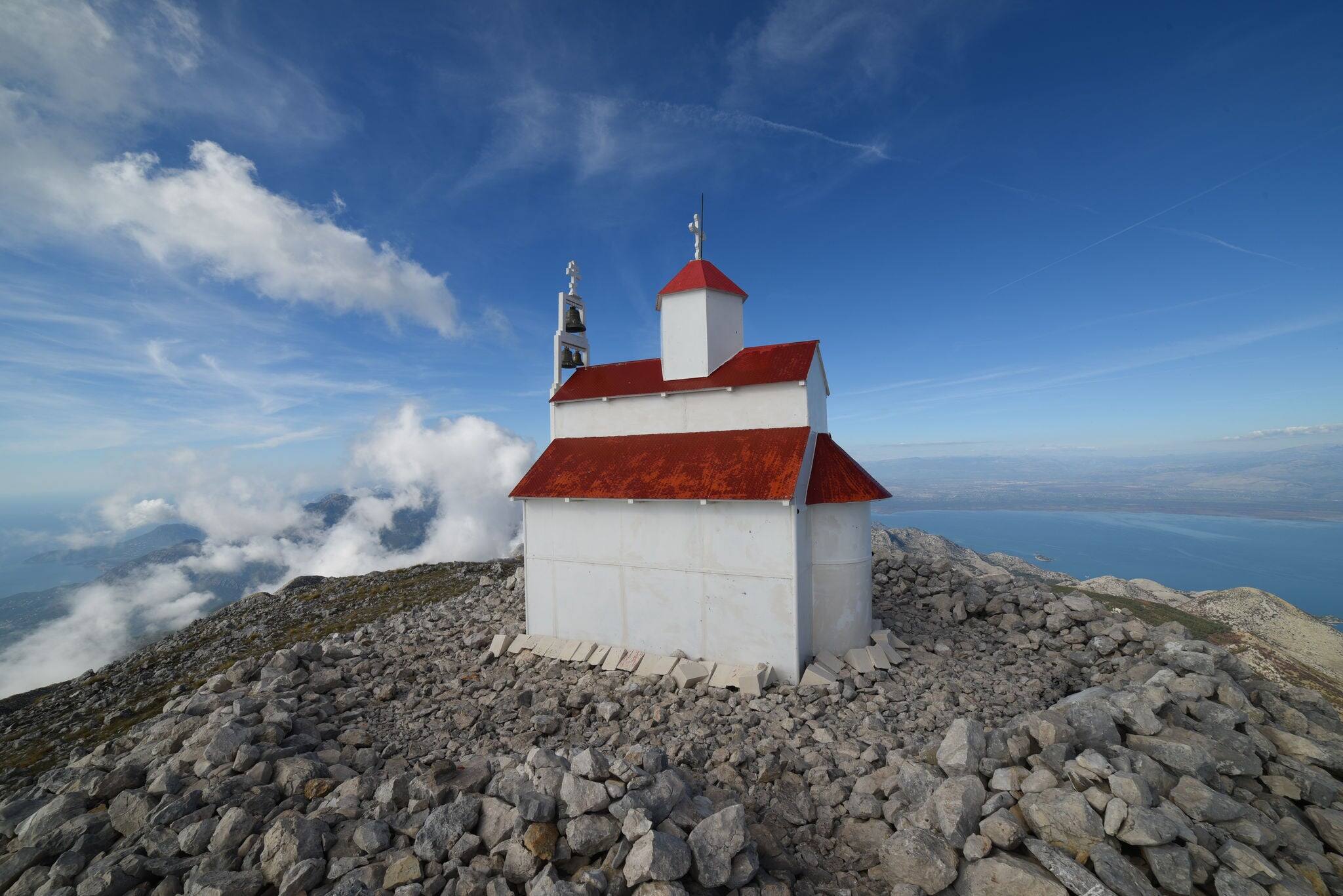 White orthodox church with red roof on the mount Rumija at Bar, Montenegro, Skadar Lake view