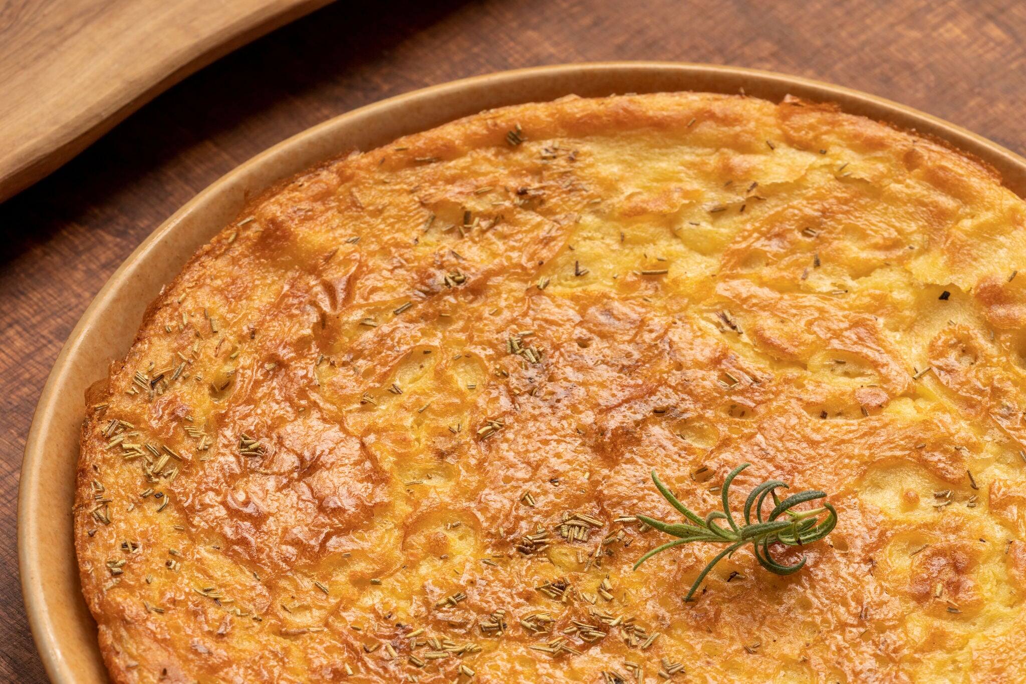 Farinata (Italian chickpea pancake) with rosemary herb. Homemade traditional Italian cuisine dish.