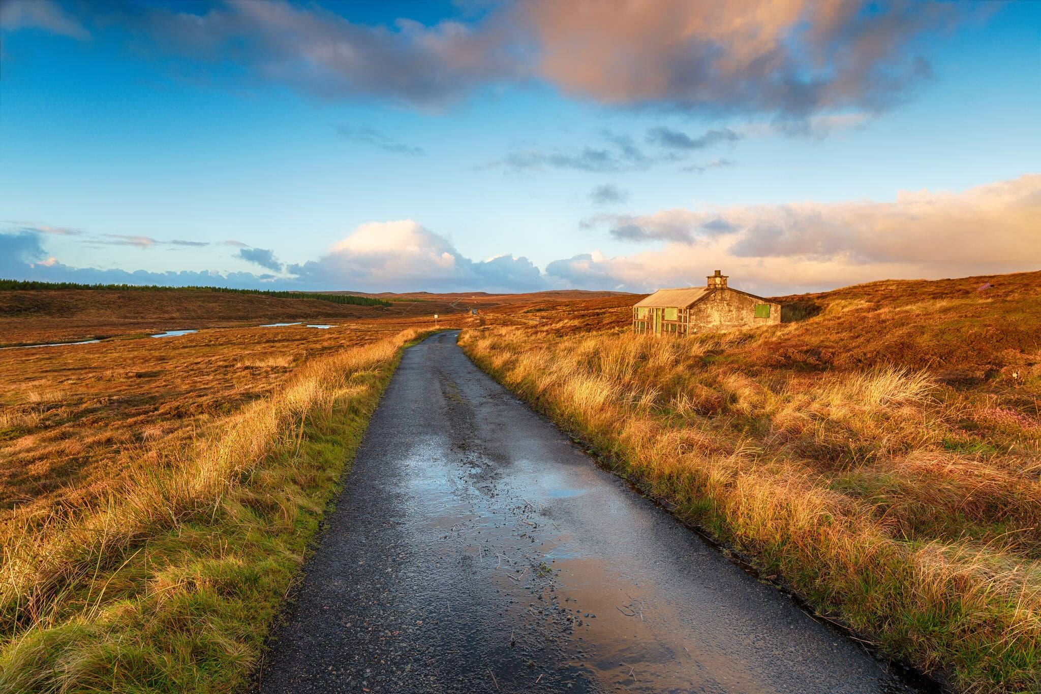 A single track road over a peat bog and past a shieling hut near Stornoway on the Isle of Lewis in the Outer Hebrides in Scotland