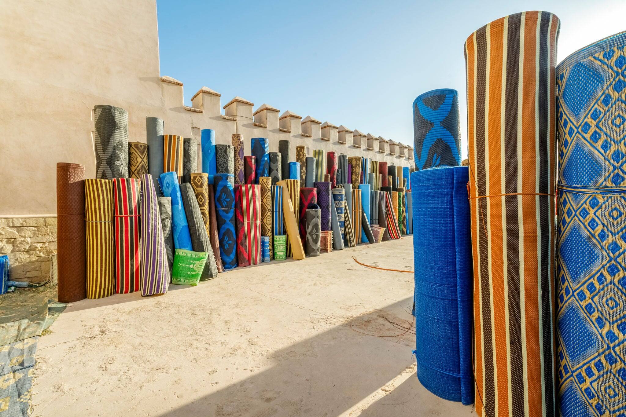 Many rolls of plastic carpet sold on African open air market in Agadir, Morocco