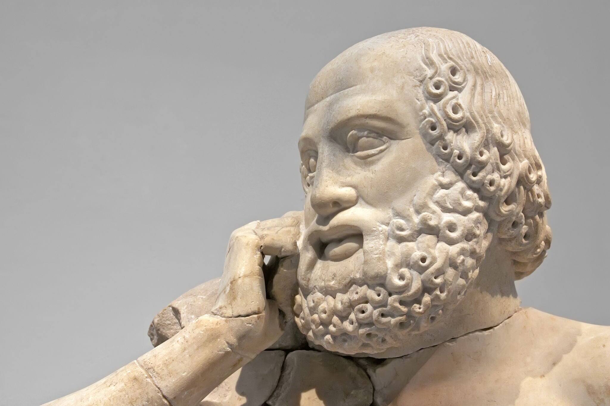 Ancient ruins of the Philippeion at Olympia, Greece. Detail of an ancient Greek statue of a human. Site of the ancient Olympic Games is situated on the Peloponnese. UNESCO world heritage site.