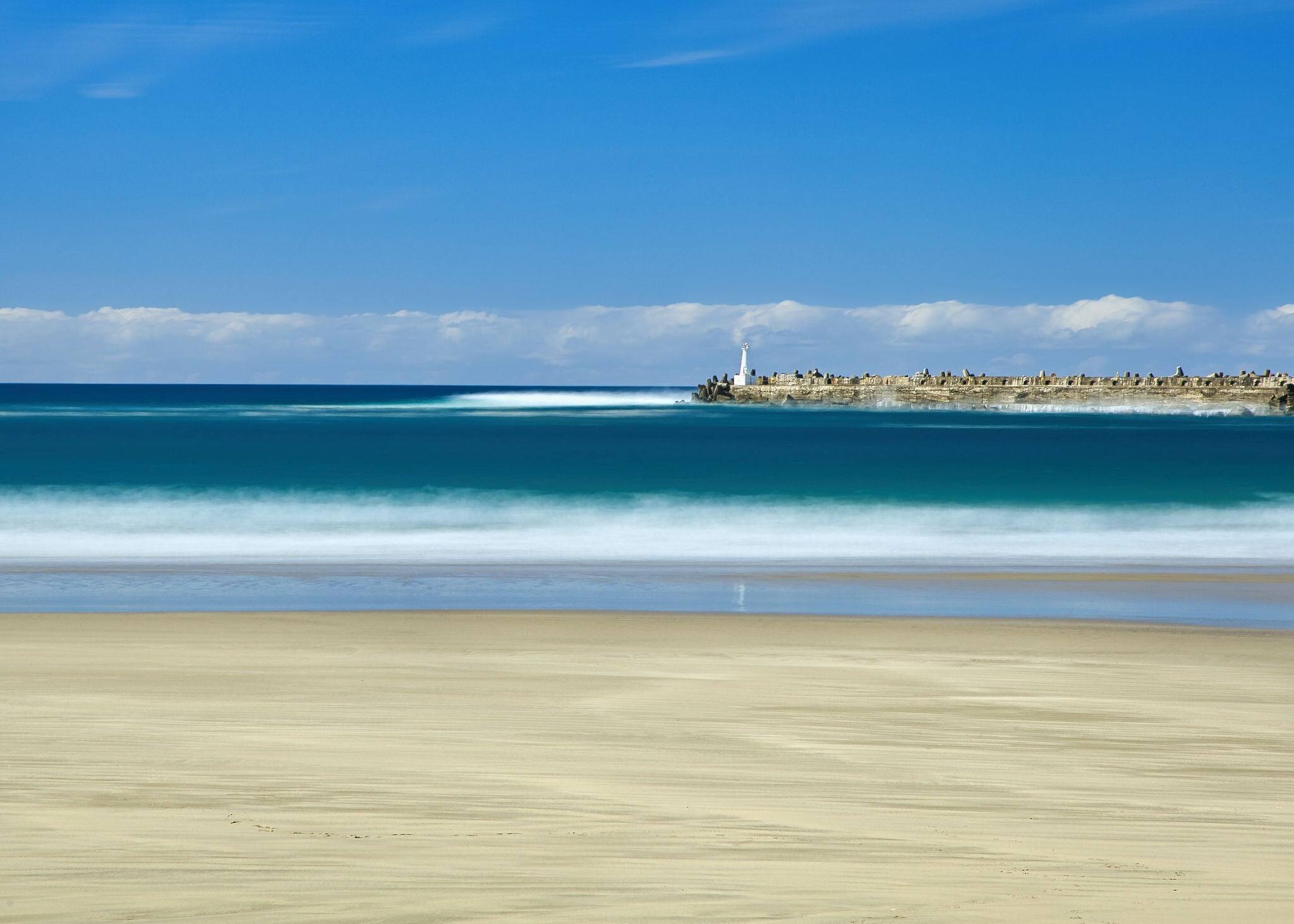 This is Orient Beach in East London, South Africa.  The Orient Pier and light beacon are visible in the background, a well-known fishing spot.