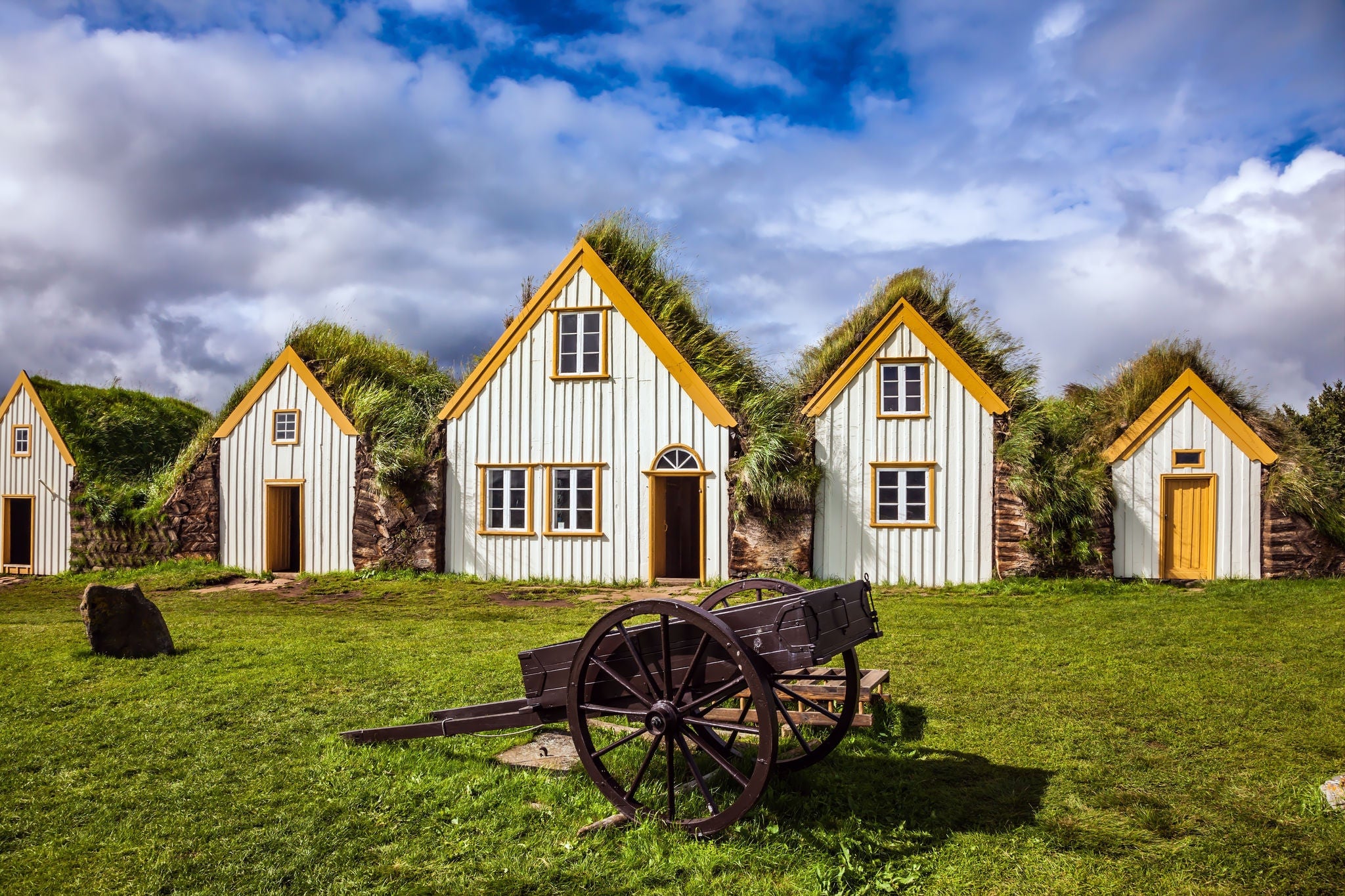 Facade of the farmhouse and ancient rural  wheelbarrow. The concept of the historical and cultural tourism. Ethnographic Museum-estate Glaumbaer, Iceland
