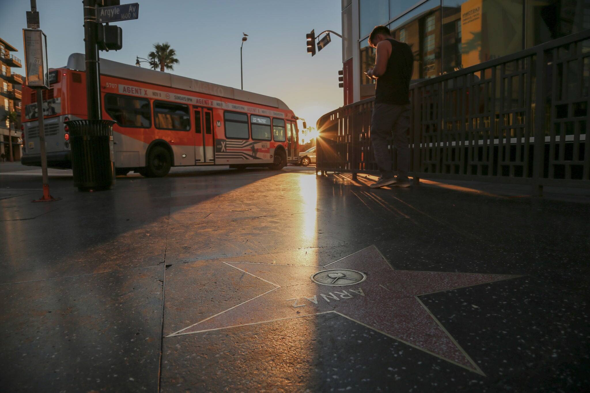 Sunrise on Hollywood Boulevard Walk of Fame as a city Bus drives by