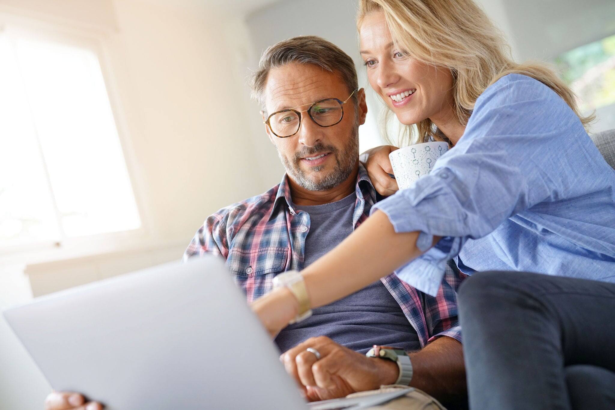 Mature couple connected on internet with laptop