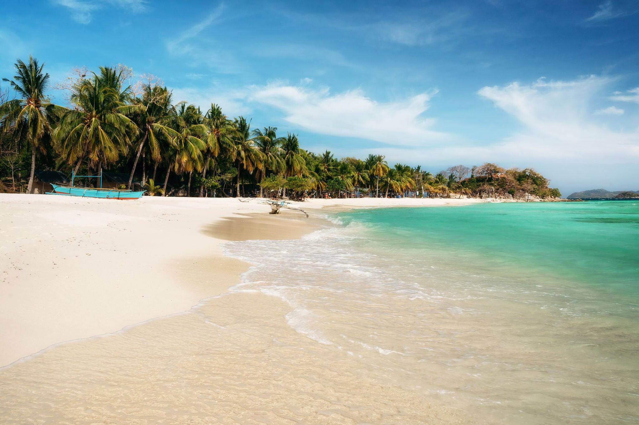 Tropical Malcapuya island with traditional philippines bangka boat, azure water and white sand beach. Travel vacation at Philippines.