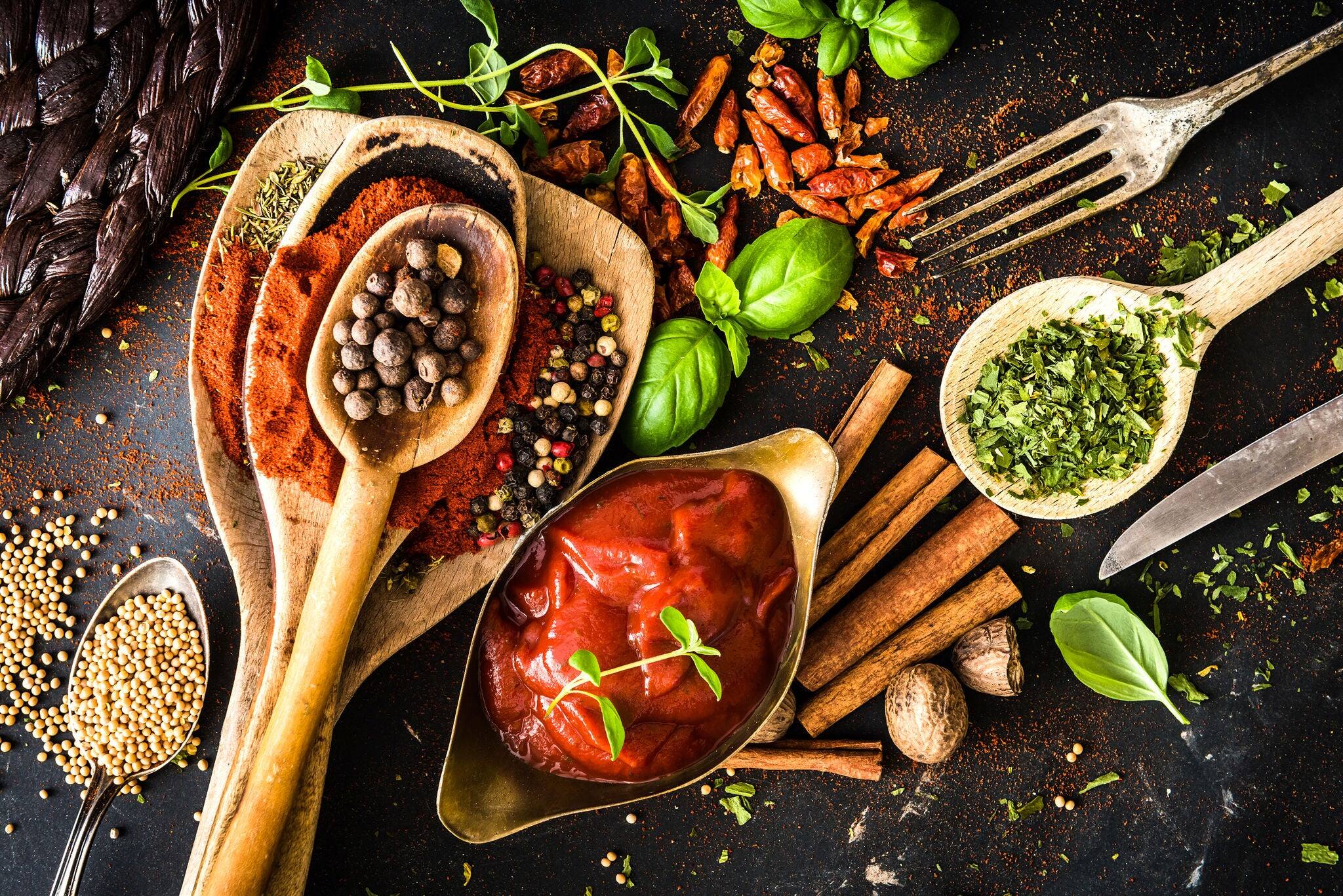tomato sauce with spices and textured black kitchen table