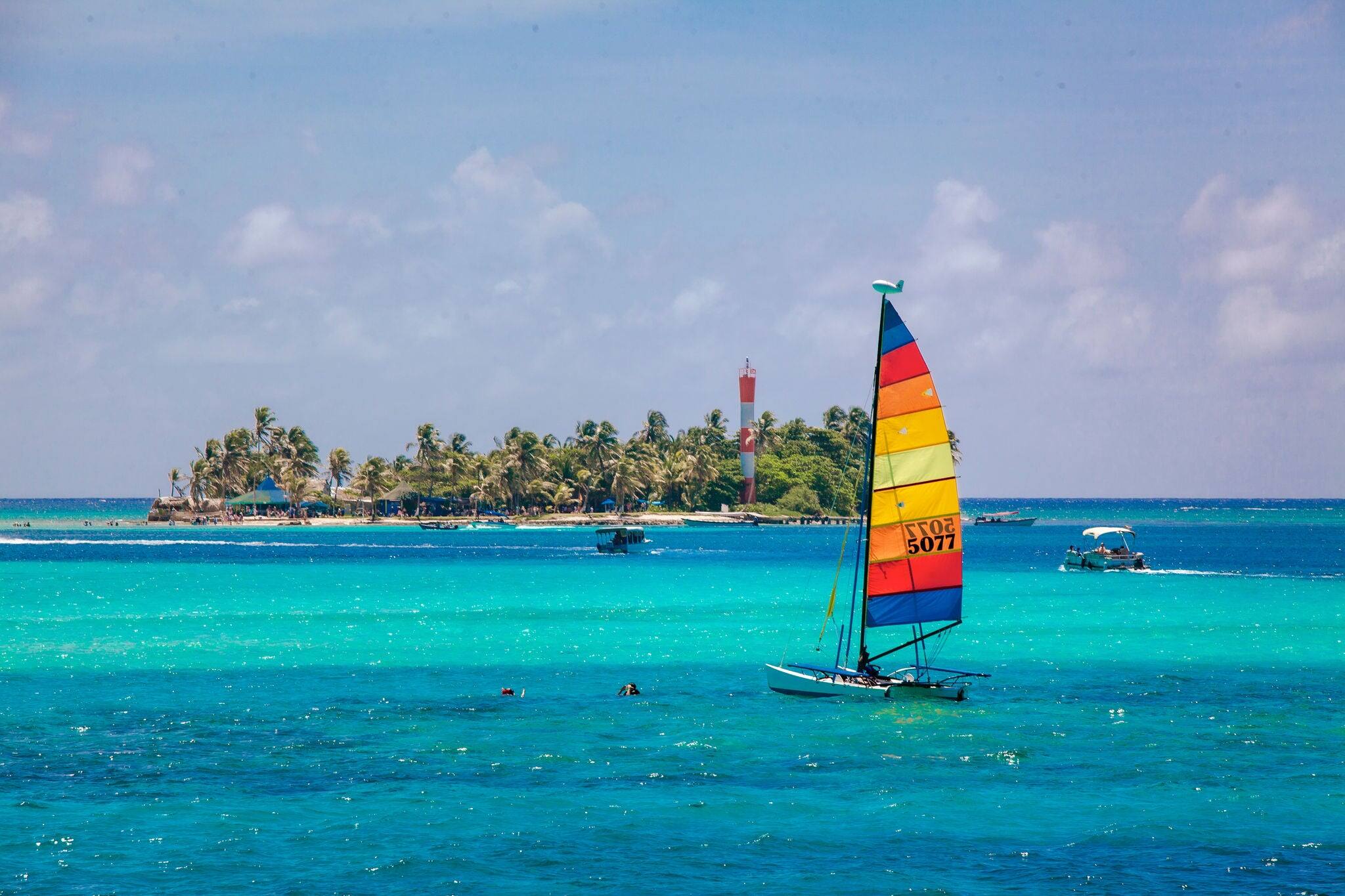 Small colorful sailboat sailing in the blue and transparent waters of the island of San Andres.