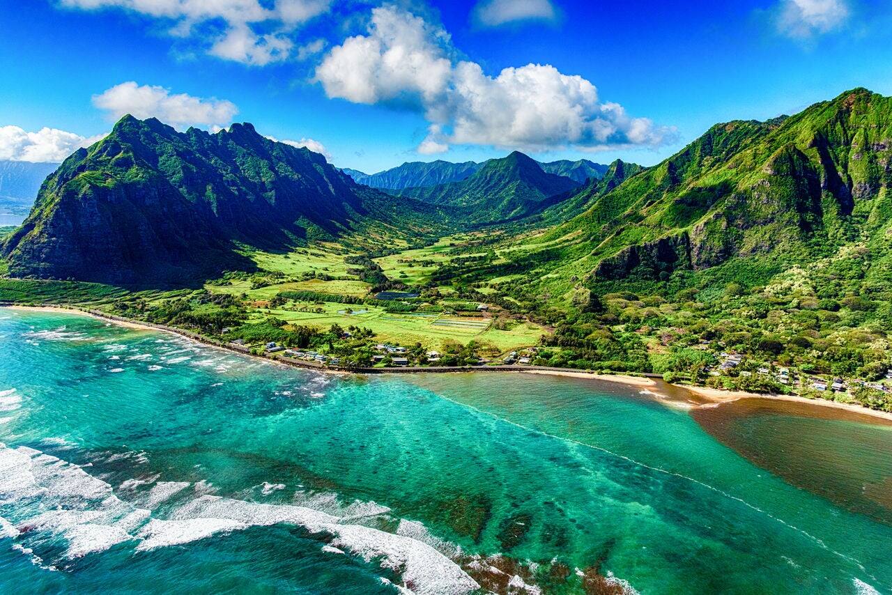 The beautiful and unique landscape of coastal Oahu, Hawaii and the Kualoa Ranch where Jurassic Park was filmed as shot from an altitude of about 1000 feet over the Pacific Ocean.