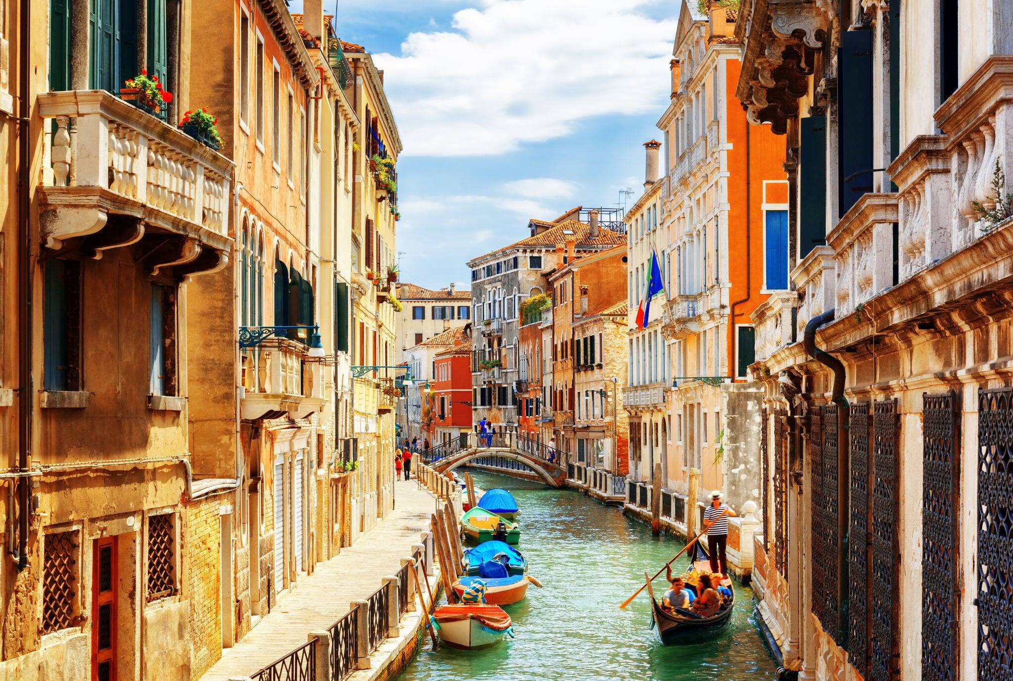 View of the Rio Marin Canal with boats and gondolas from the Ponte de la Bergami in Venice, Italy. Venice is a popular tourist destination of Europe.
