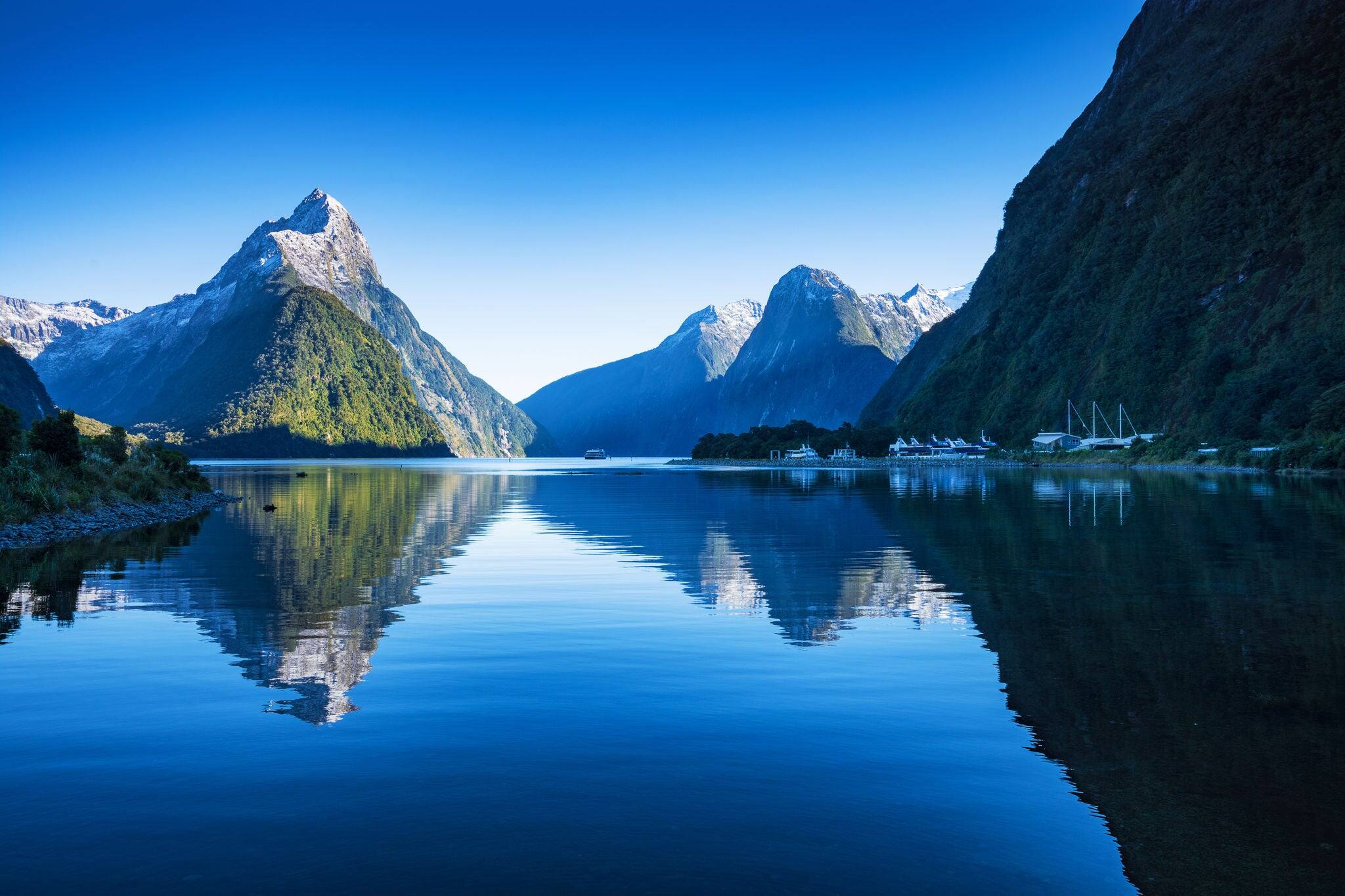 Clear sky in Milford sound, Fjordland national park, south island, New Zealand with a reflection of Mitre peak in the water.