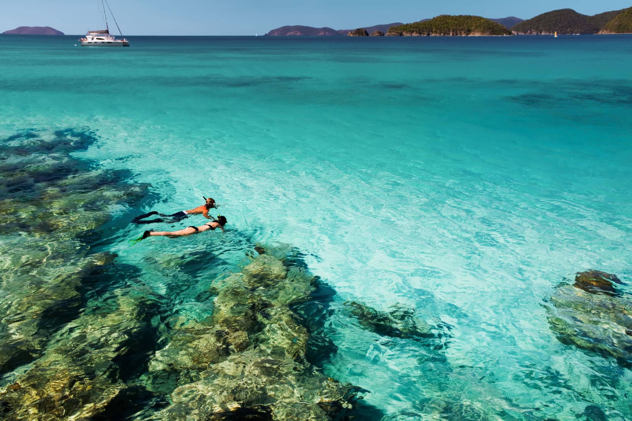 couple holding hands while snorkeling in the Caribbean crystal clear waters